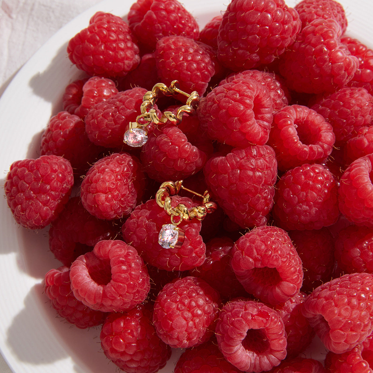 Zirconia drop hoops arranged on raspberries