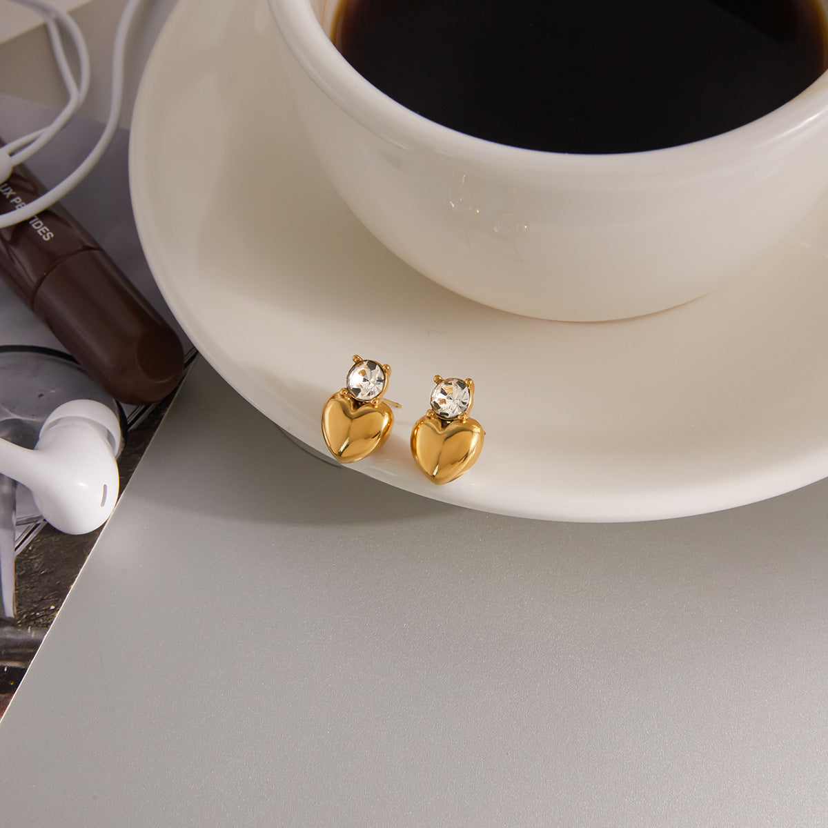 heart drop stud earrings styled beside a white cup