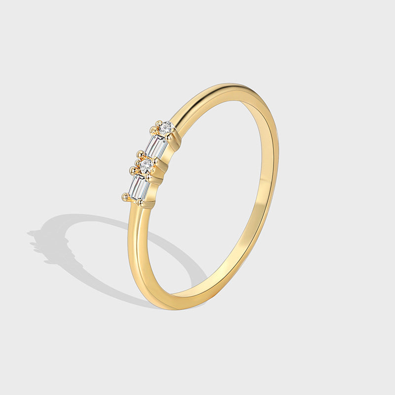 isolated gold plated brass band ring with baguette and round clear stones
