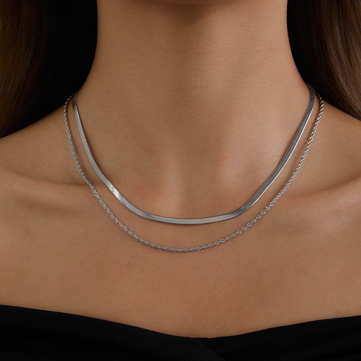 Layered stainless steel chains shown against a dark top