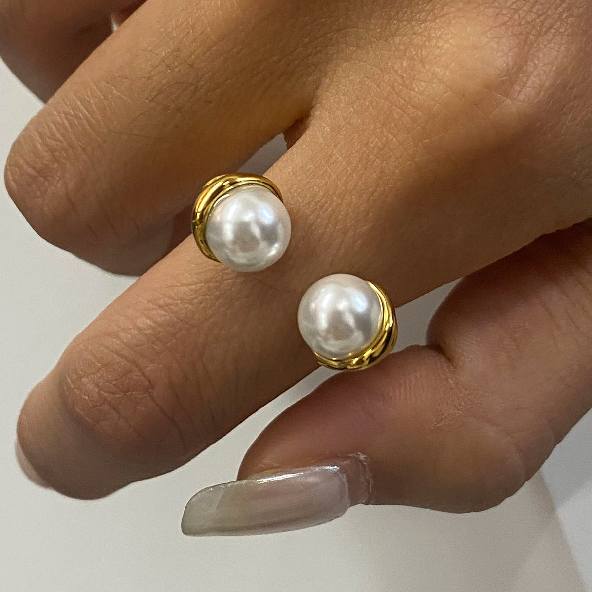 Gold plated double pearl-look open ring worn on a hand