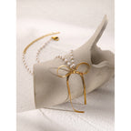 Bow and pearl-look bead necklace arranged on a display block