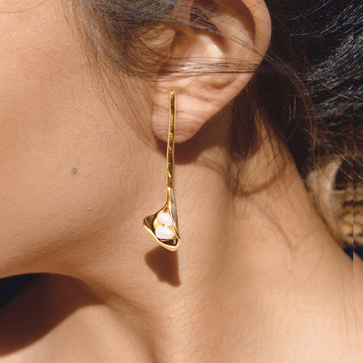 side view of sculptural calla lily pearl drop earring