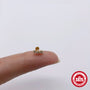 Gold finish curved zirconia stud shown for scale