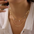 Mixed charm necklace layered with an elongated-link necklace