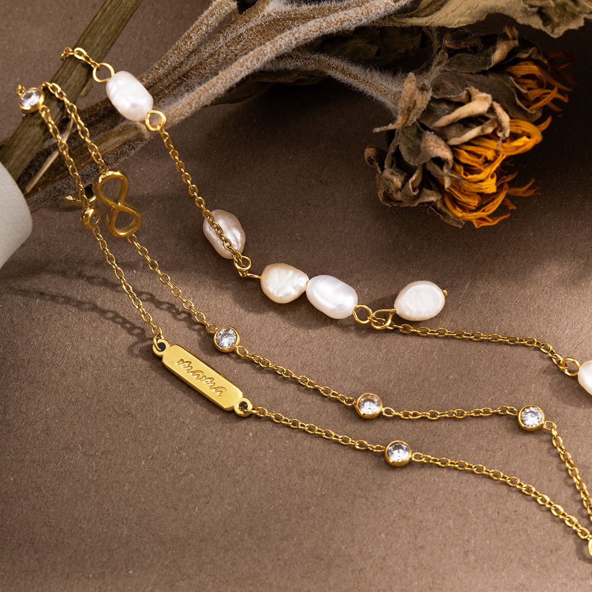 Close-up of pearl stations and infinity charm bracelet chains