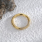 top view of slim gold plated zirconia band on pale surface