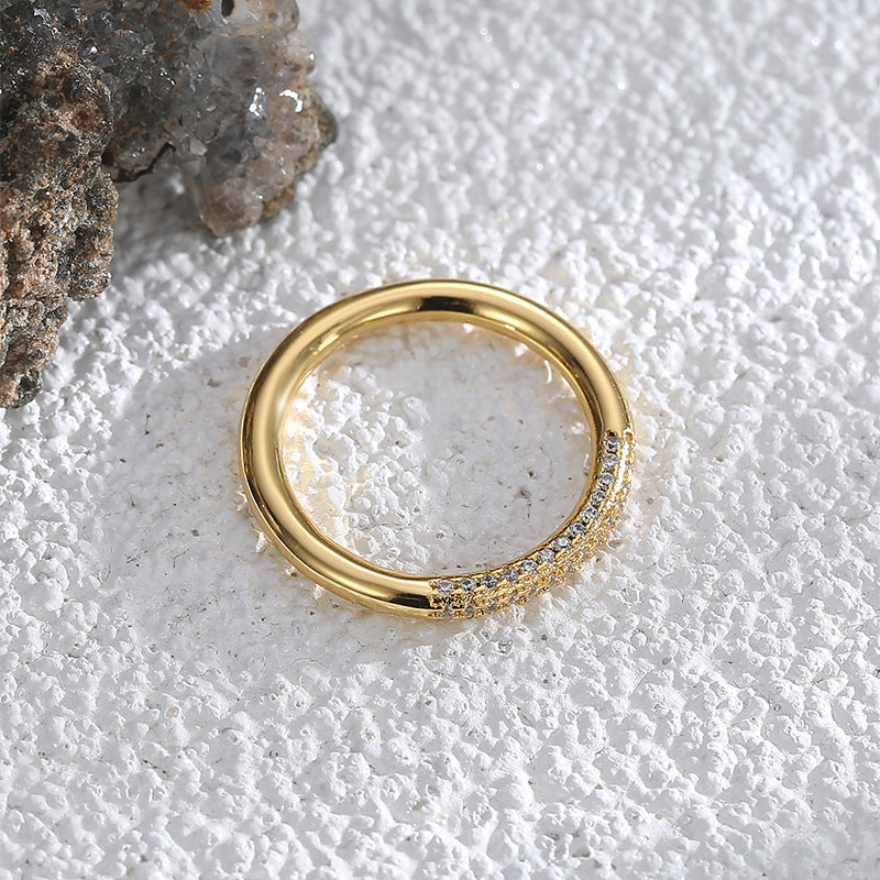 top view of slim gold plated zirconia band on pale surface