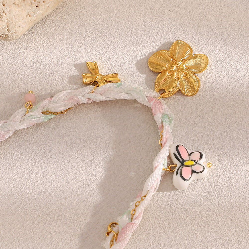 Reverse of gold tone flower charm with bow and outlined flower