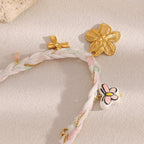 Reverse of gold tone flower charm with bow and outlined flower