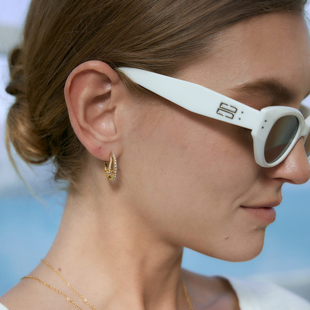 Stone-lined celestial hoop worn with white sunglasses
