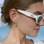 Stone-lined celestial hoop worn with white sunglasses