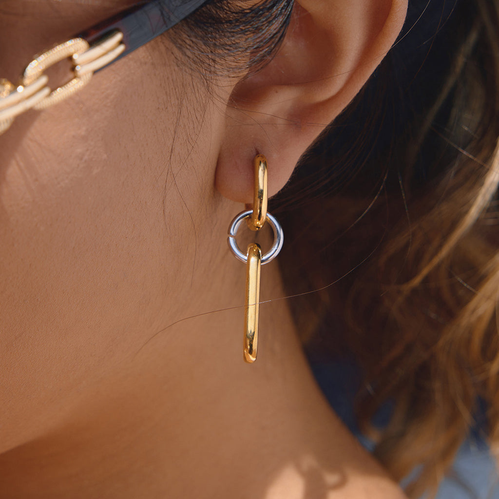 gold plated and silver-finish elongated linked earring worn on ear