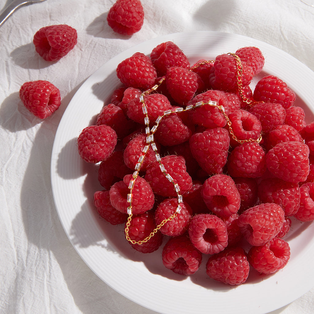 Rectangular stone hand chain beside raspberries