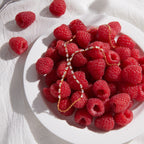 Rectangular stone hand chain beside raspberries