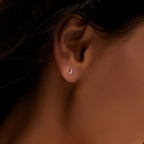 petite silver crescent moon piercing stud worn on the ear