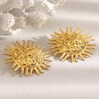 textured sunburst statement earrings styled beside white coral
