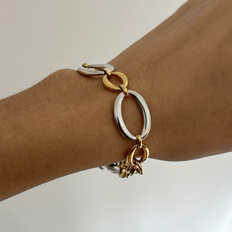 Two-tone alternating oval link bracelet worn on a wrist