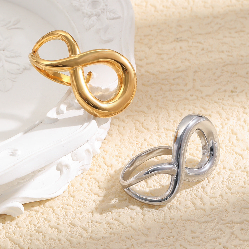 gold plated and silver-finish infinity open rings on a textured surface