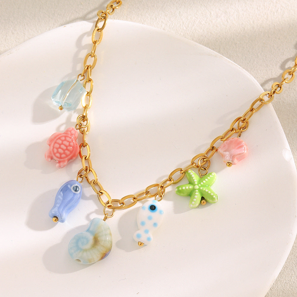 multicolor sea-life charms arranged along a gold plated oval-link chain