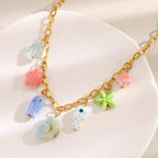 multicolor sea-life charms arranged along a gold plated oval-link chain