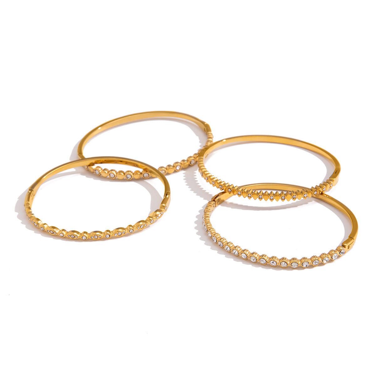 Four gold-tone stackable bangle designs shown together