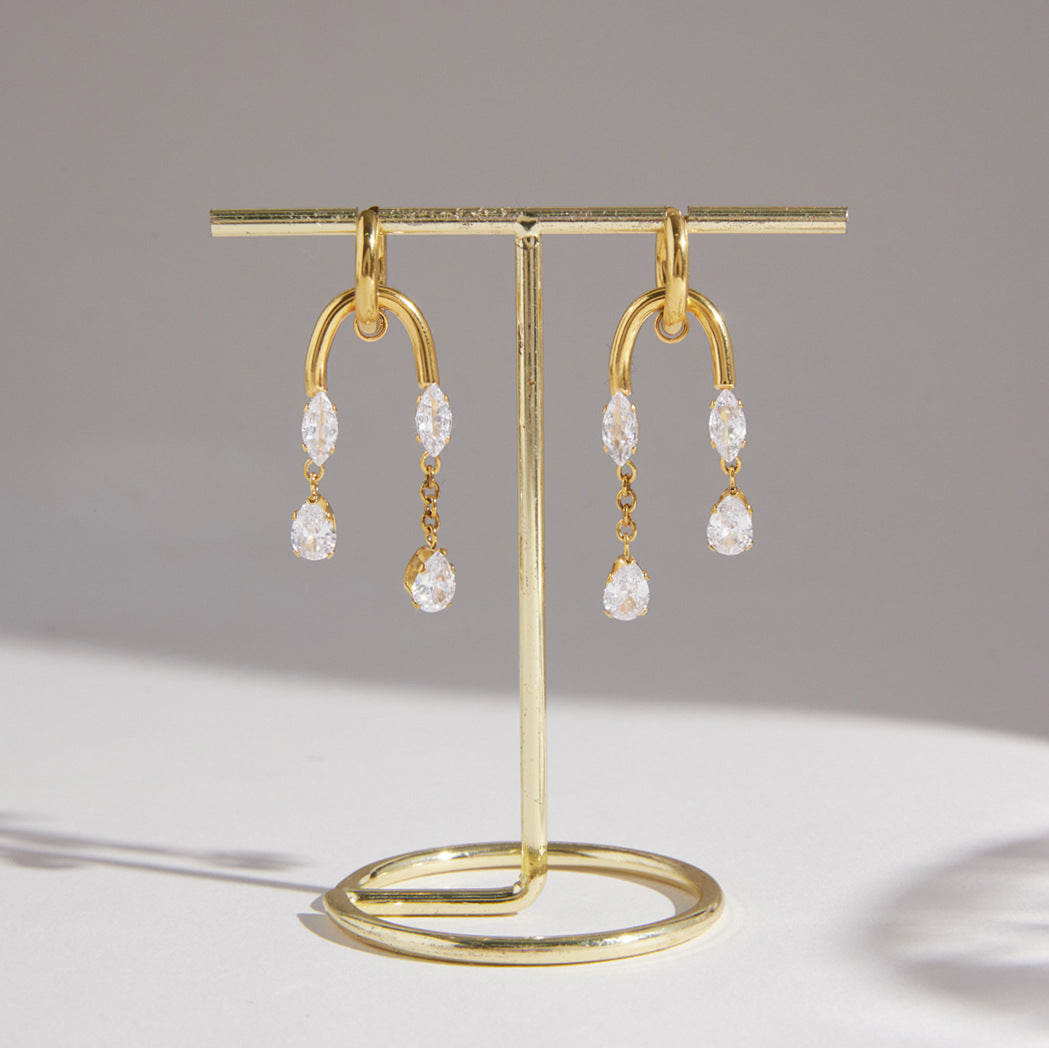Pair of clear stone tassel earrings hanging on a stand