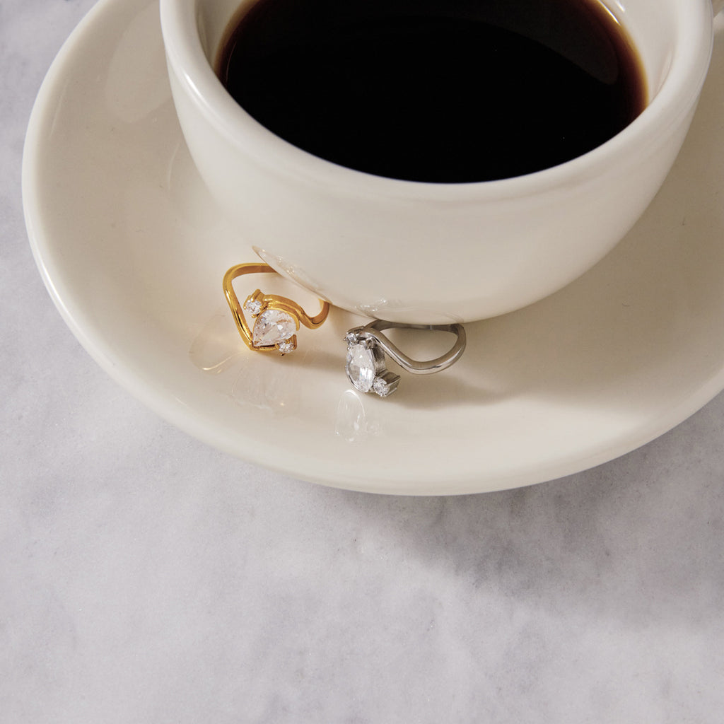 Two pear-stone rings beside a coffee cup