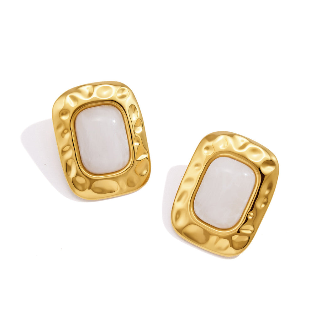 Pair of white resin studs with rounded gold tone borders