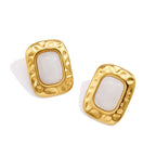 Pair of white resin studs with rounded gold tone borders