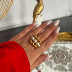 Triple-row gold and pearl-look bead ring worn on a hand