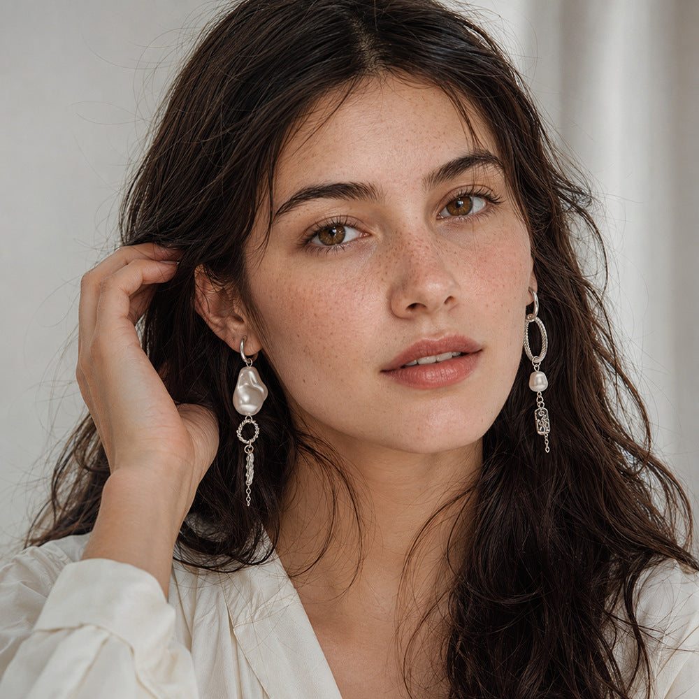 Asymmetric imitation pearl tassel earrings worn on a model