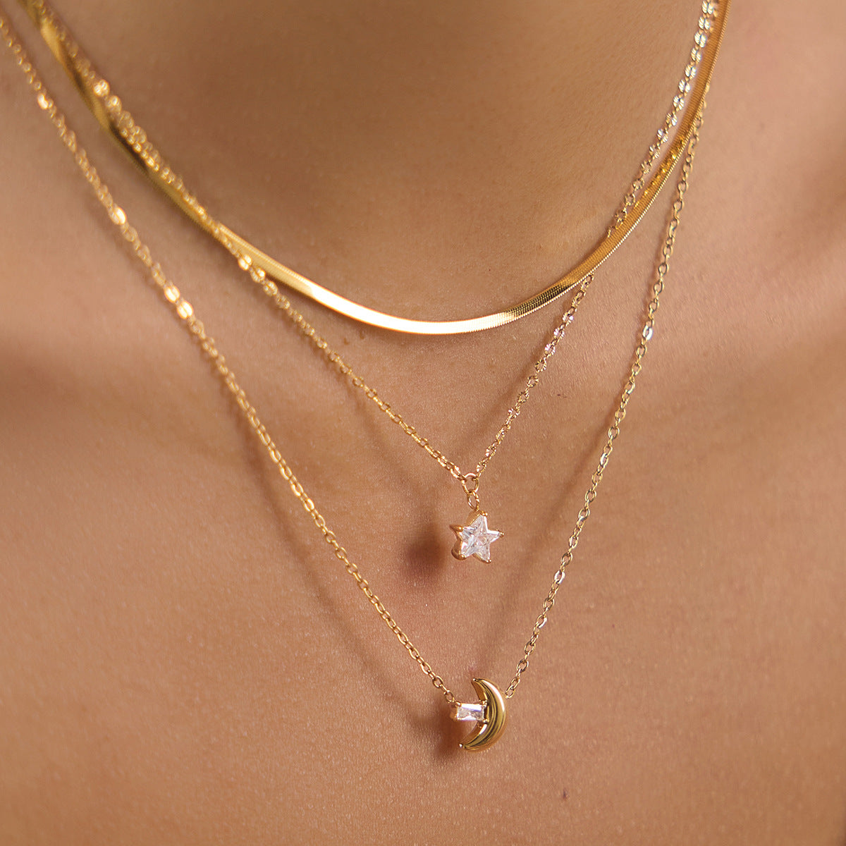 Three-layer moon and star necklace close-up at neckline