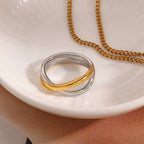 Two-tone crossover band ring styled beside a gold chain