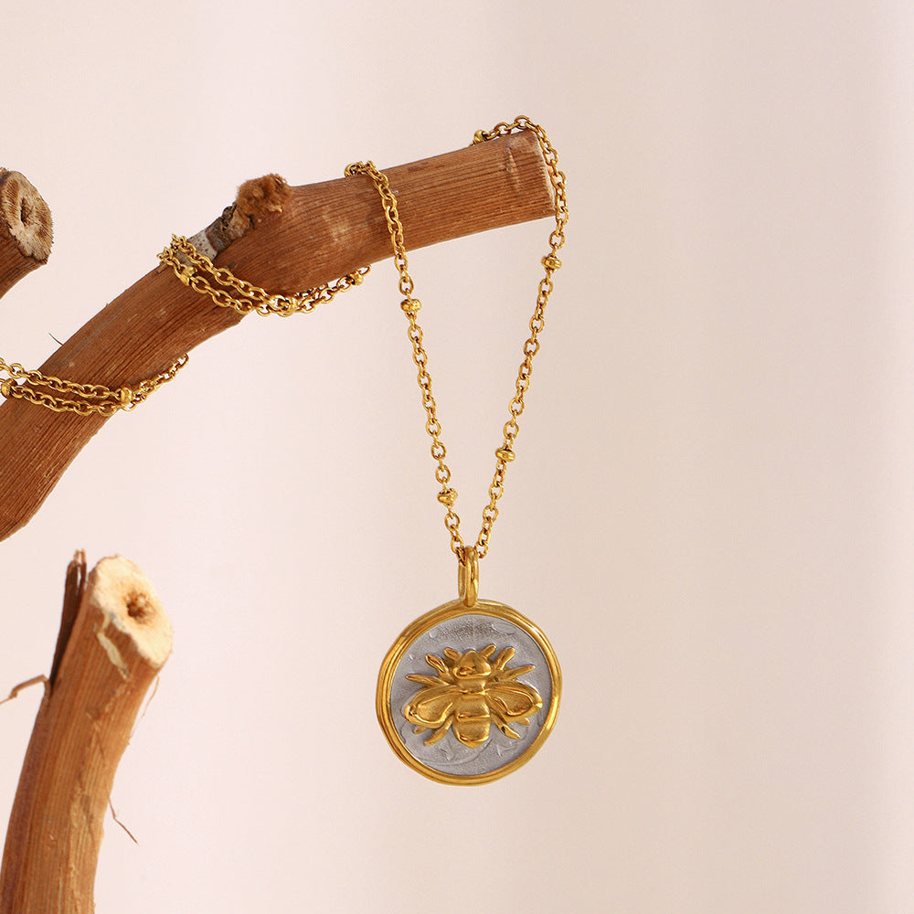 two-tone stainless steel bee medallion necklace held by the chain