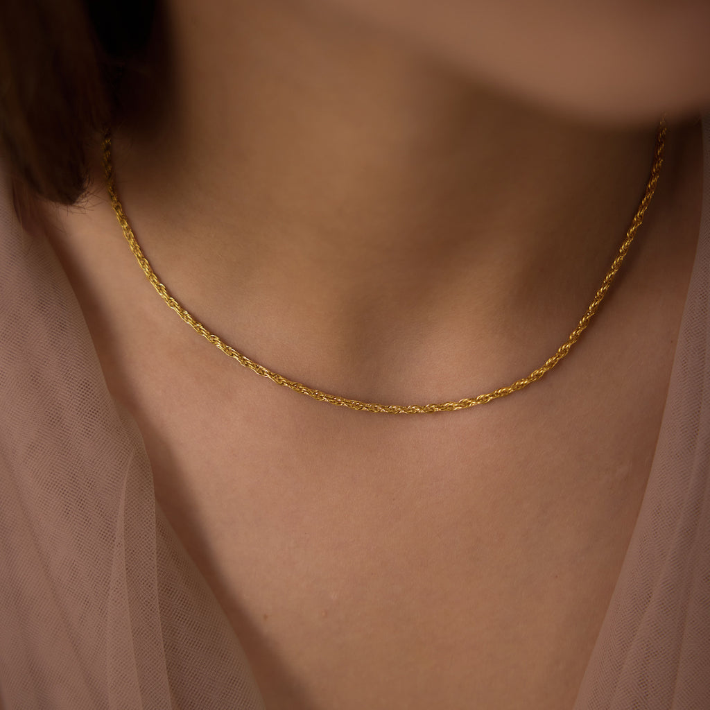 Fine twisted chain necklace worn at the collarbone