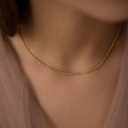 Fine twisted chain necklace worn at the collarbone