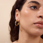 Gold-tone textured link open hoop worn in profile