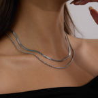 Silver-color flat and rope chain necklace worn at the neckline