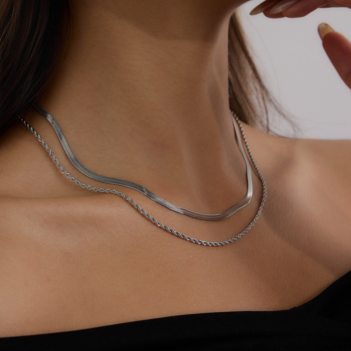 Silver-color flat and rope chain necklace worn at the neckline