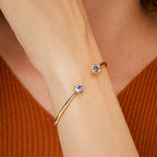 wrist close-up of opposing purple triangle stone cuff ends