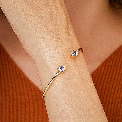 wrist close-up of opposing purple triangle stone cuff ends