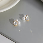 pair of gold plated pear-cut pearlized stud earrings on a tray