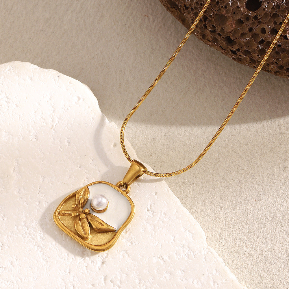 gold plated imitation pearl pendant necklace in a soft flat lay