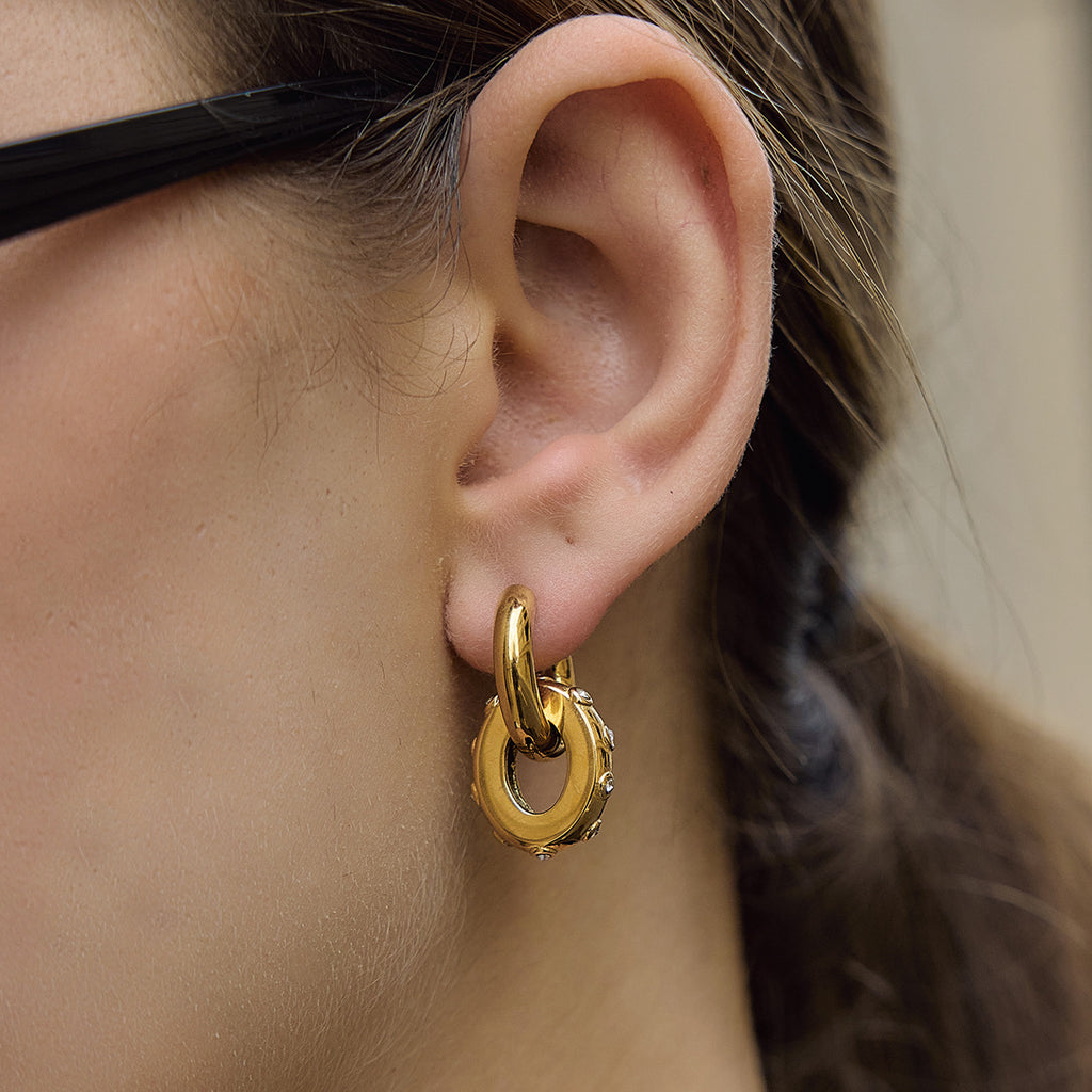 Oval drop hoop earring worn on an ear