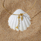 Two fish charms displayed against a shell