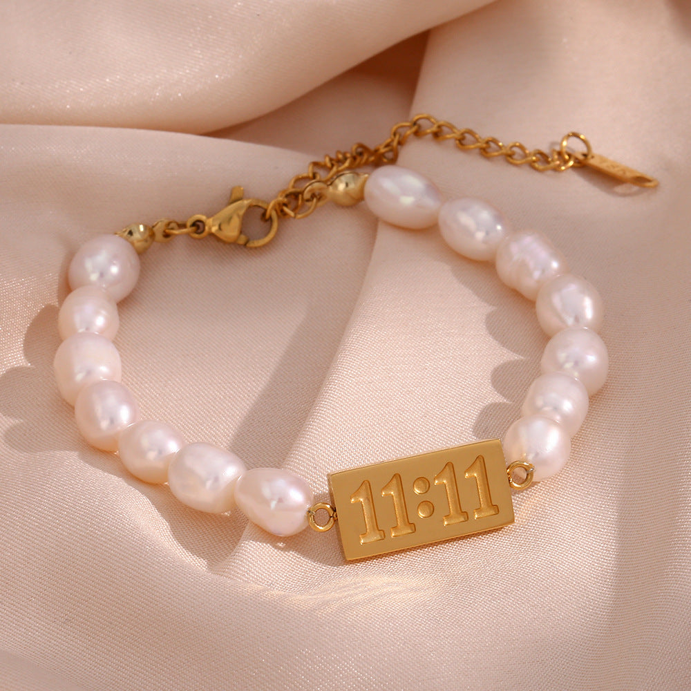 Freshwater pearl bracelet with a gold-tone 11:11 plaque on fabric