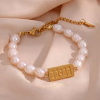 Freshwater pearl bracelet with a gold-tone 11:11 plaque on fabric