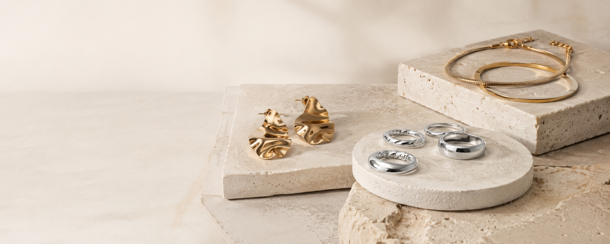 Gold and silver tone jewelry arranged on light stone display blocks