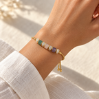 Adjustable natural stone bracelet shown worn on a wrist beside a white linen sleeve